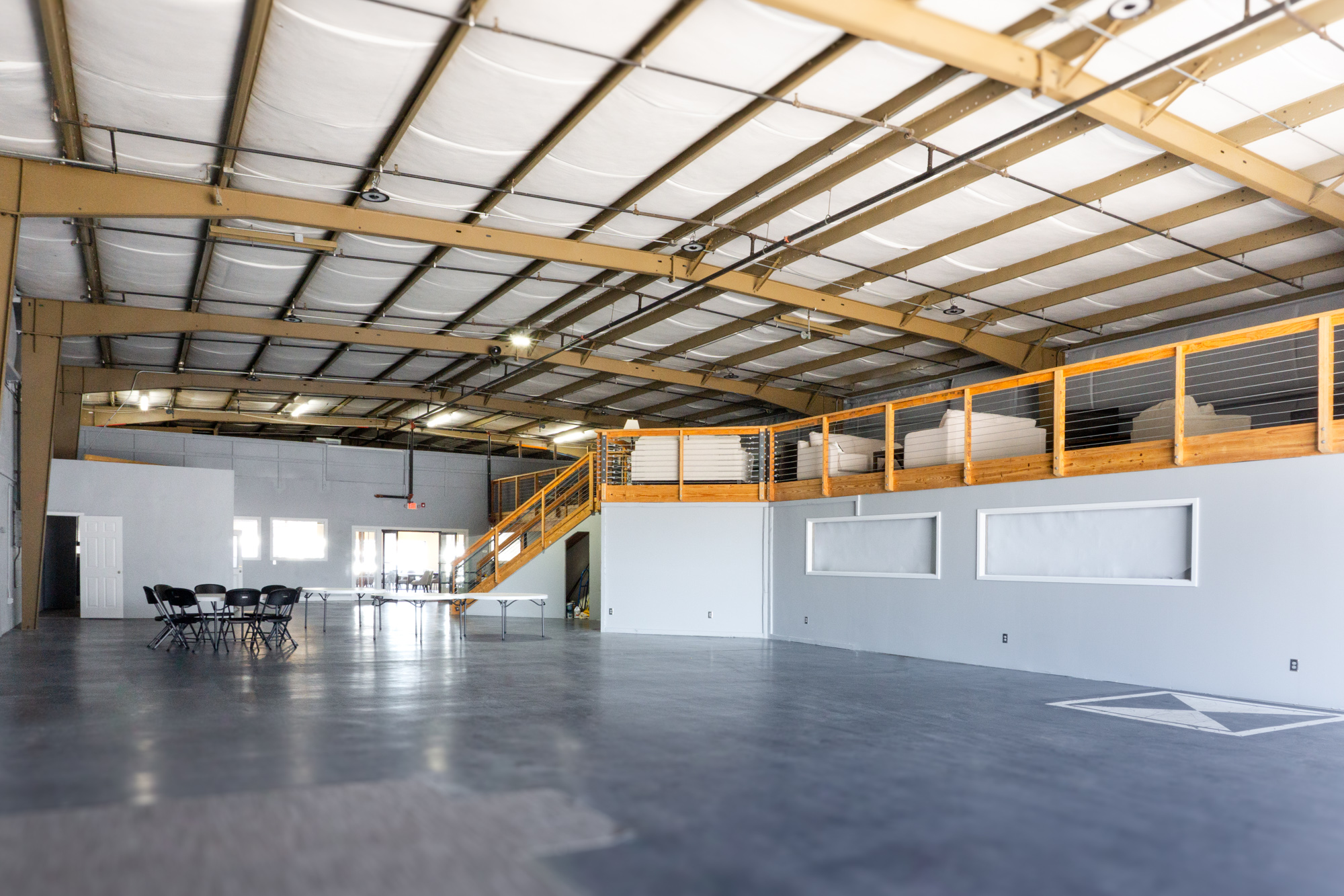 The Loft — upstairs balcony space with wooden railing overlooking the main hall