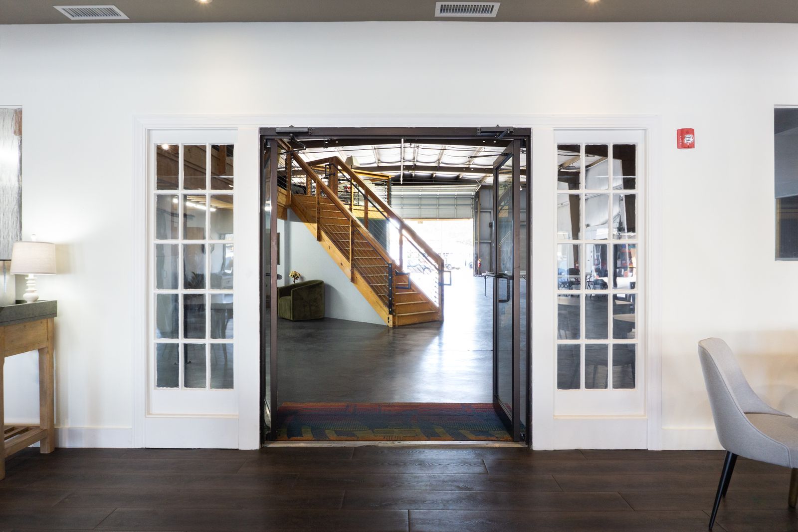 View into the Big Room through open French doors with the loft staircase beyond