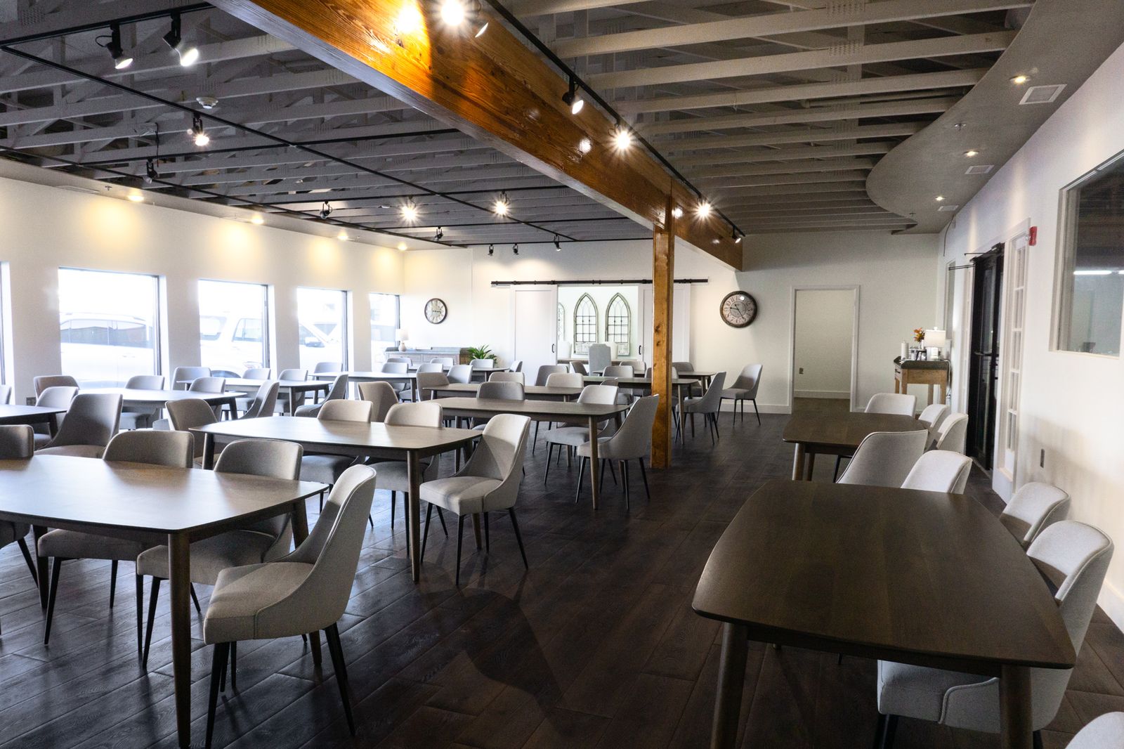 Meeting room beside a row of daylight windows with a reclaimed-wood support beam