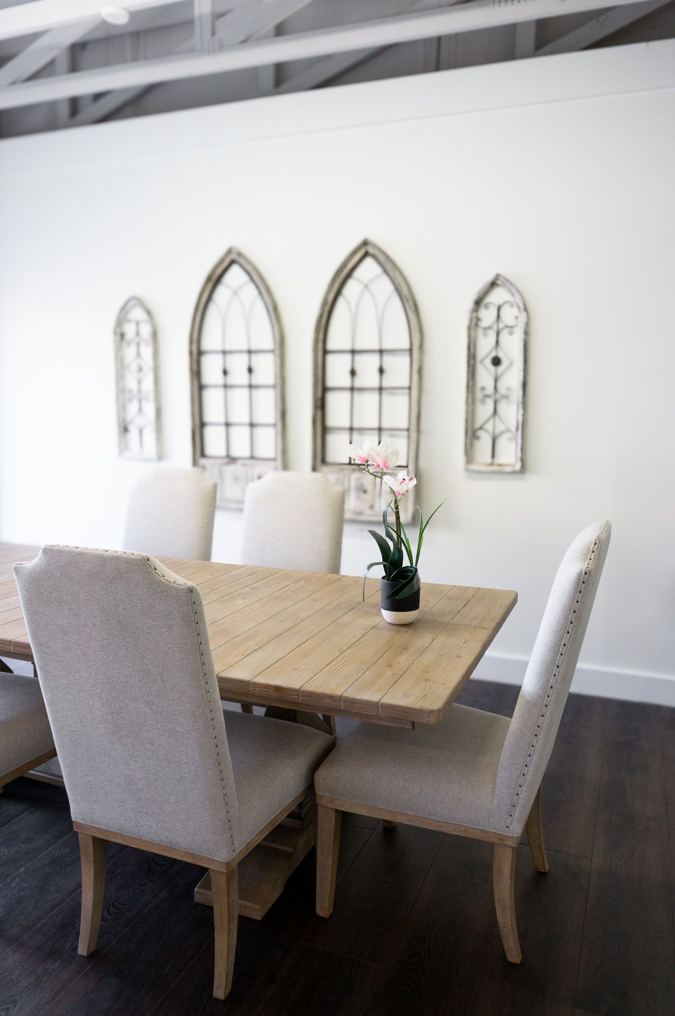 Intimate signing room with a wood table and cushioned chairs under arched window-style accents