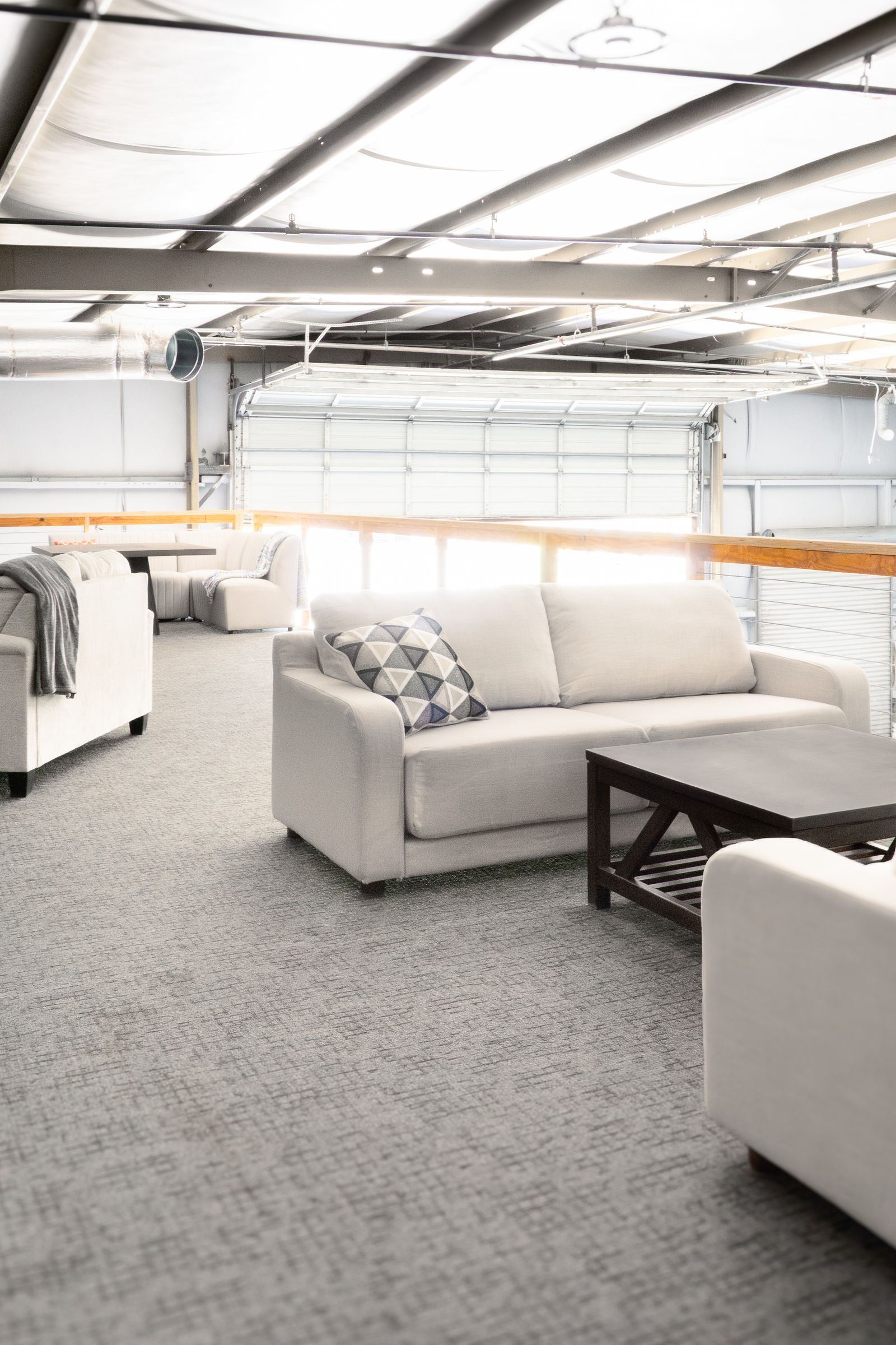 Wide interior of the main hall with lounge sofas under an exposed metal roof